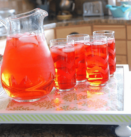 pitcher and chevron glasses with a red drink inside 