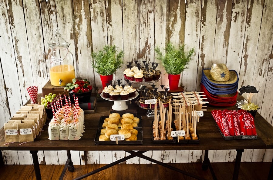 cowboy birthday party table with food and desserts 
