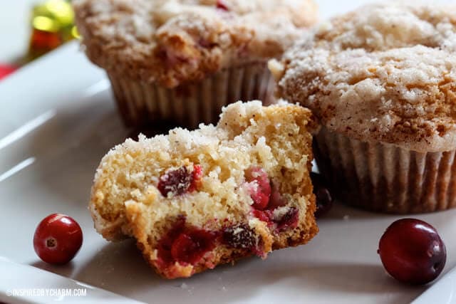 A close up of a crumb topped cranberry eggnog muffin sliced in half 