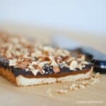 caramel chocolate almond tart on a cutting board with knife