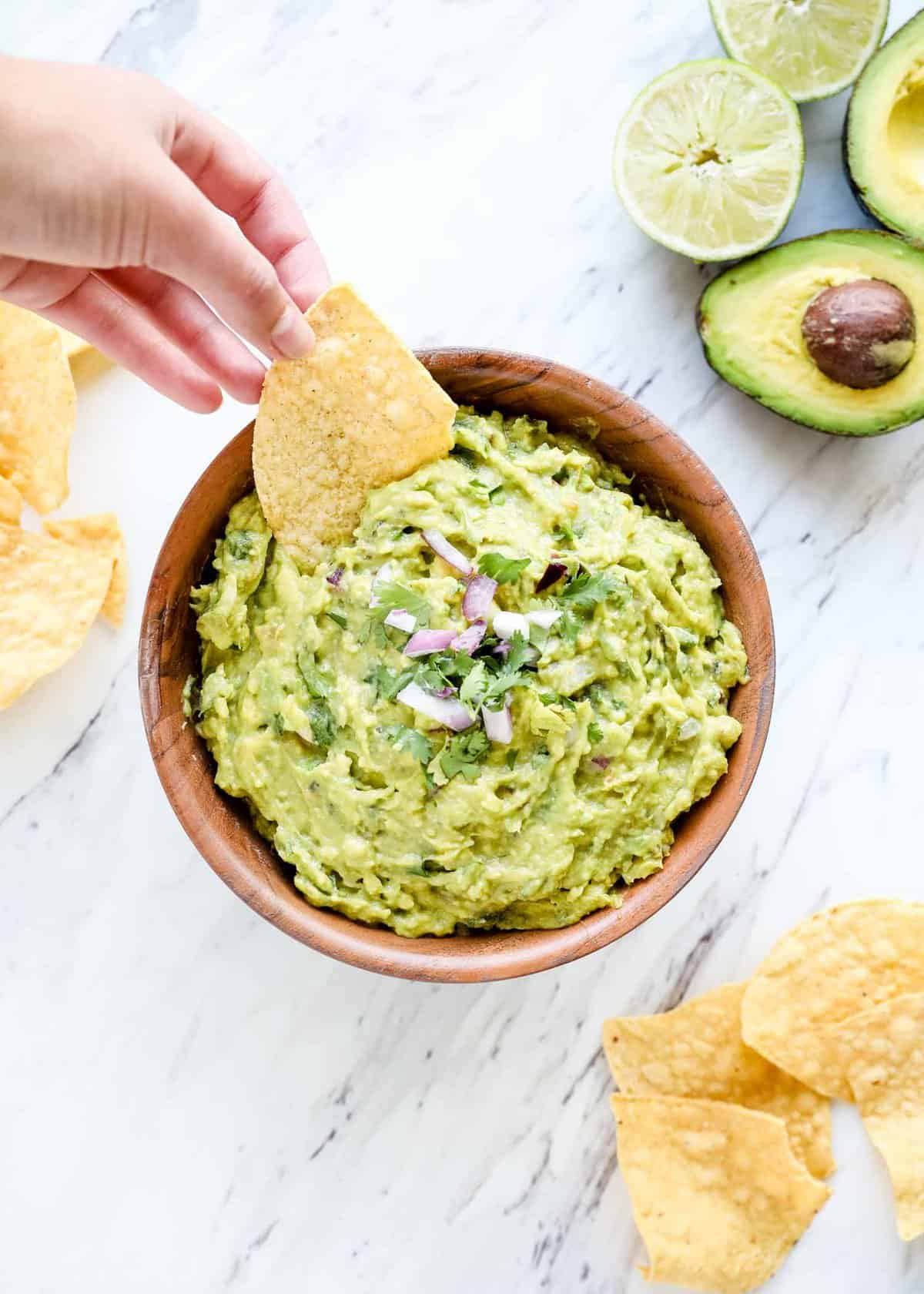 Dipping a tortilla chip in homemade guacamole.