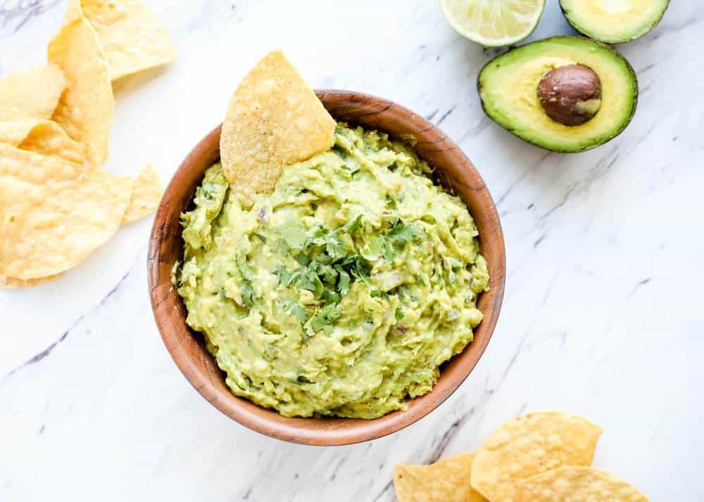 Bowl of homemade guacamole with tortilla chips.
