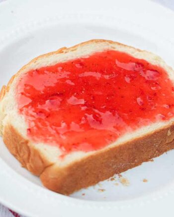 piece of homemade bread topped with fresh strawberry jam