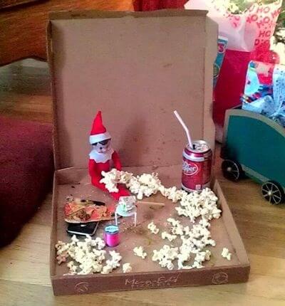 Top 50 of the BEST Elf on the Shelf ideas - So many fun ideas to do with your Elf leading up to Christmas! Your family will love these list amazing list of elf ideas! Elf eating popcorn in a pizza box