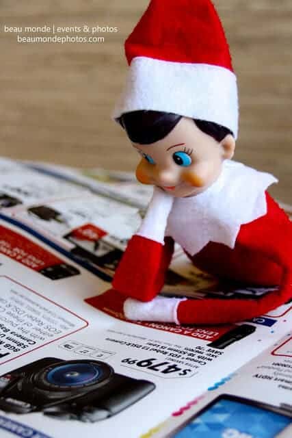 Top 50 of the BEST Elf on the Shelf ideas - So many fun ideas to do with your Elf leading up to Christmas! Your family will love these list amazing list of elf ideas! Elf looking at the paper