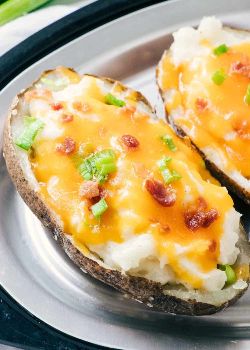 twice baked potato with cheese, bacon bits and green onions 