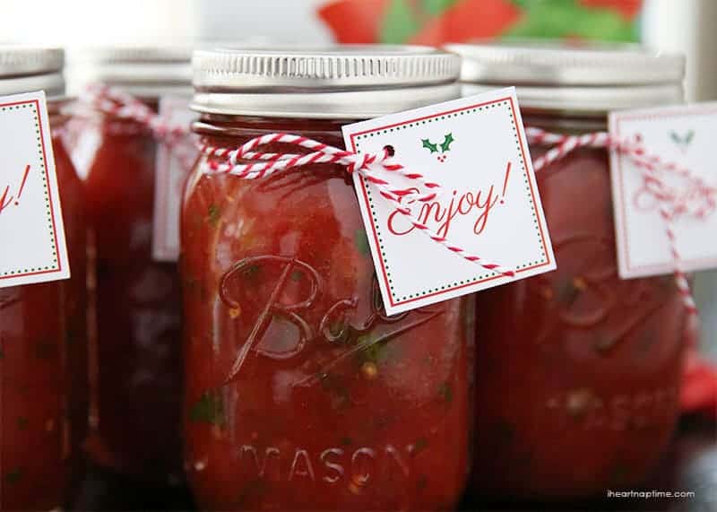 A cute and yummy homemade salsa gift idea for Christmas. Includes FREE printable salsa labels and gift tags to add an extra festive touch. Salsa in a mason jar with a Christmas tag.