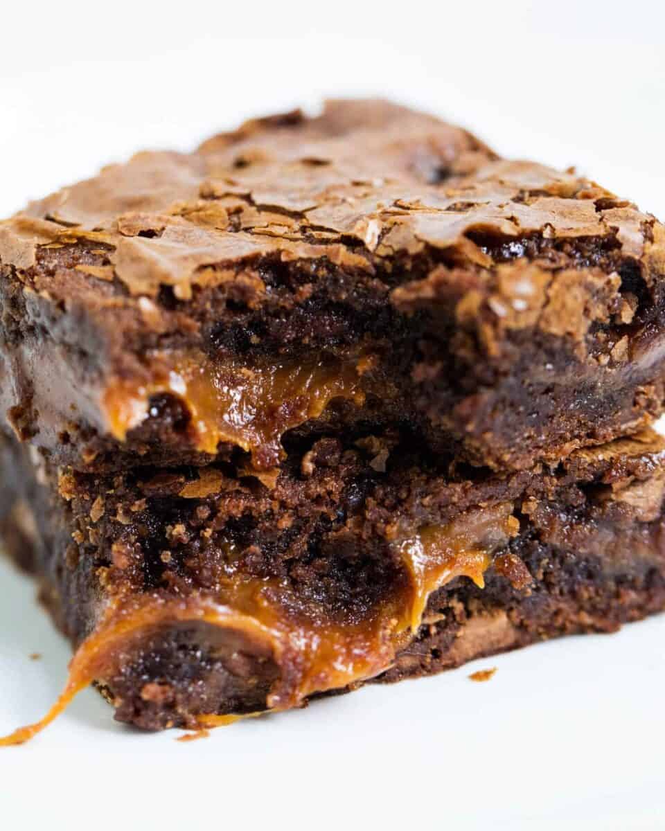 stack of caramel fudge brownies with caramel oozing out 
