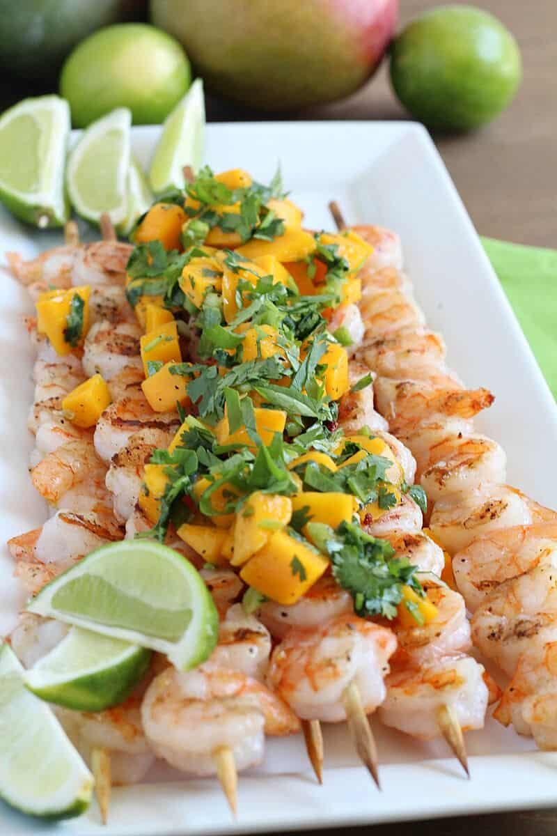 plate of grilled shrimp skewers with mango salsa