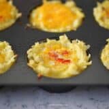 close up of egg and hashbrown nests in pan