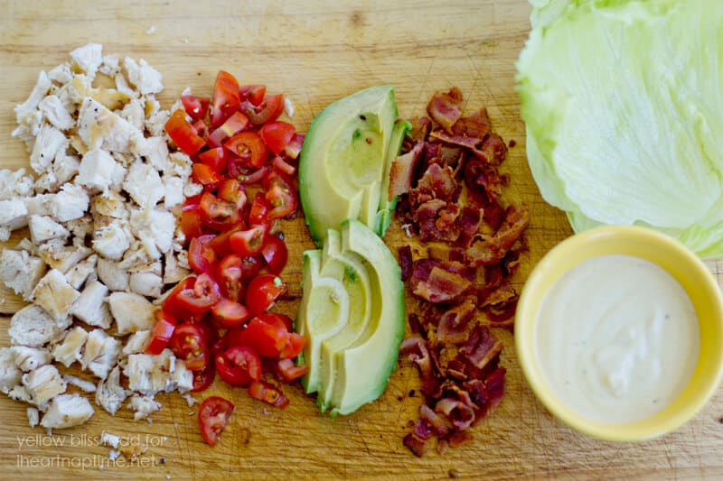 Diced ingredients for chicken club wrap on cutting board.