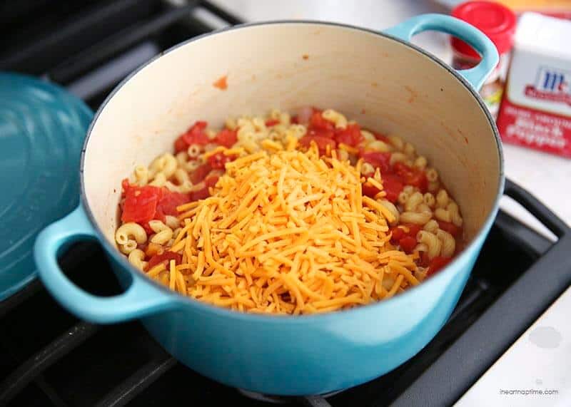 Making homemade mac and cheese with bacon on the stove.