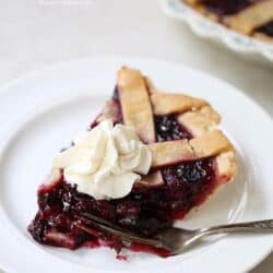 piece of razzleberry pie with whipped cream on a plate