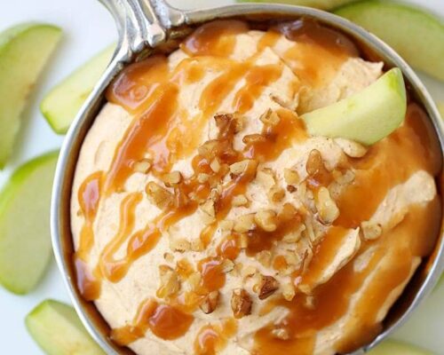 bowl of pumpkin cheesecake dip with caramel drizzled on top