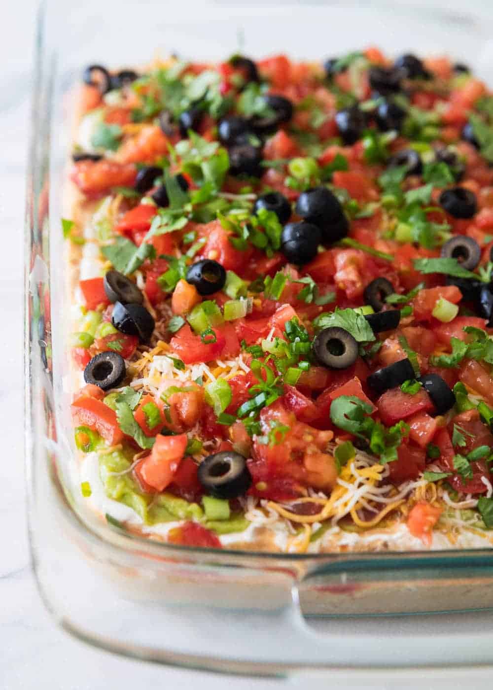 close up of 7 layer dip in a baking dish 