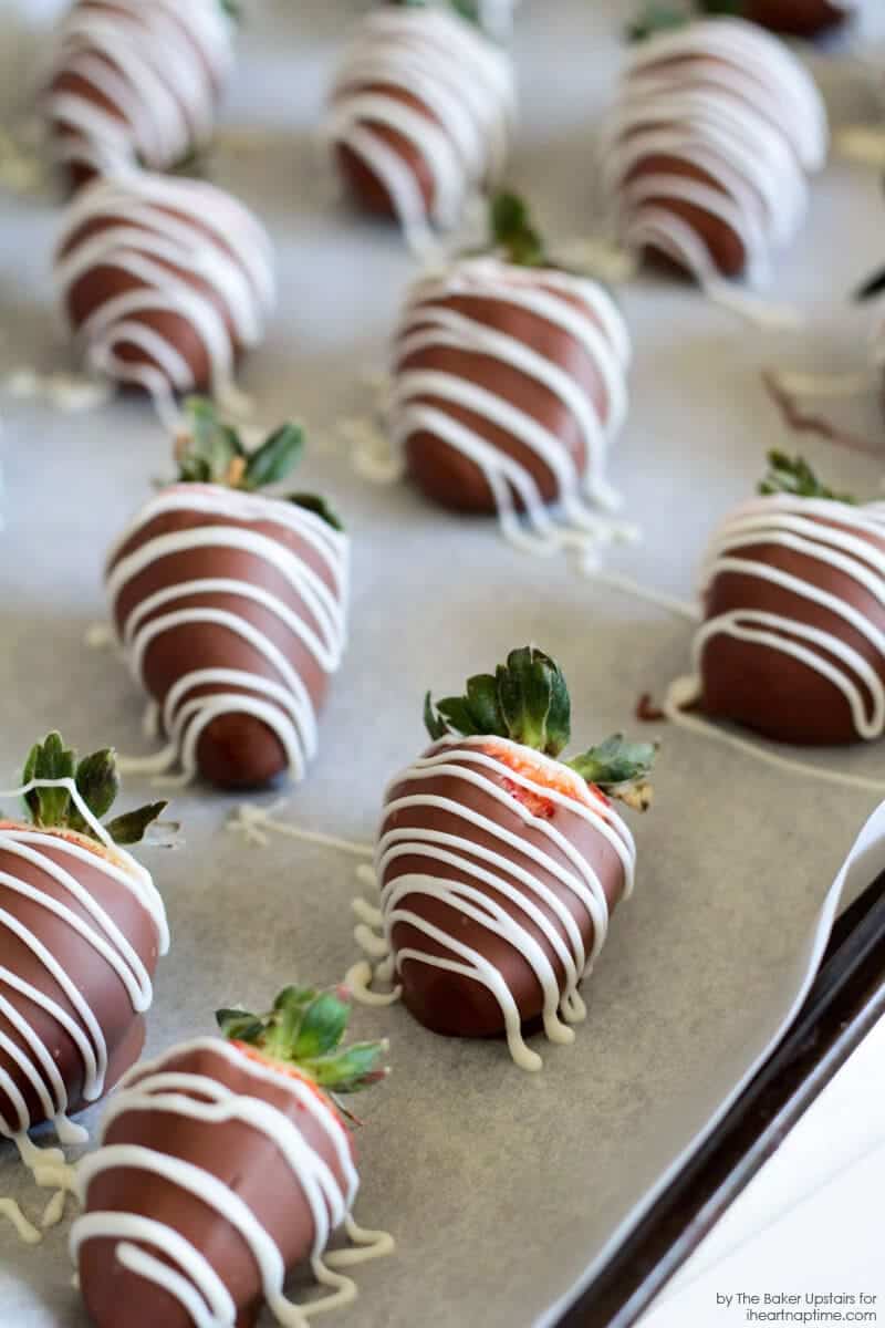 Chocolate covered strawberries on a baking sheet with wax paper.