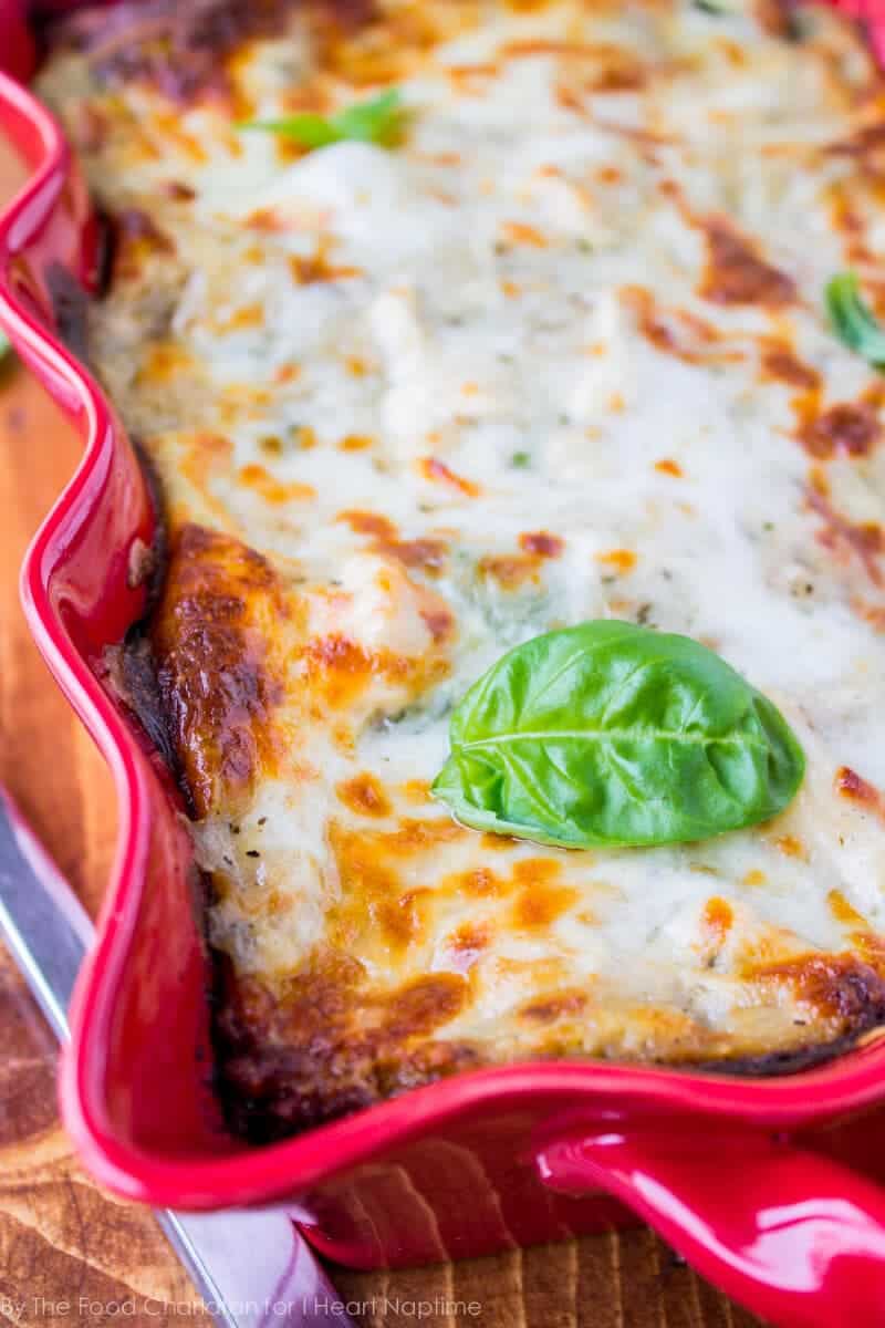 white chicken lasagna with pesto in a red baking dish 