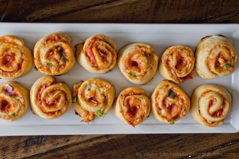 2 rows of pizza pinwheels on a white plate.