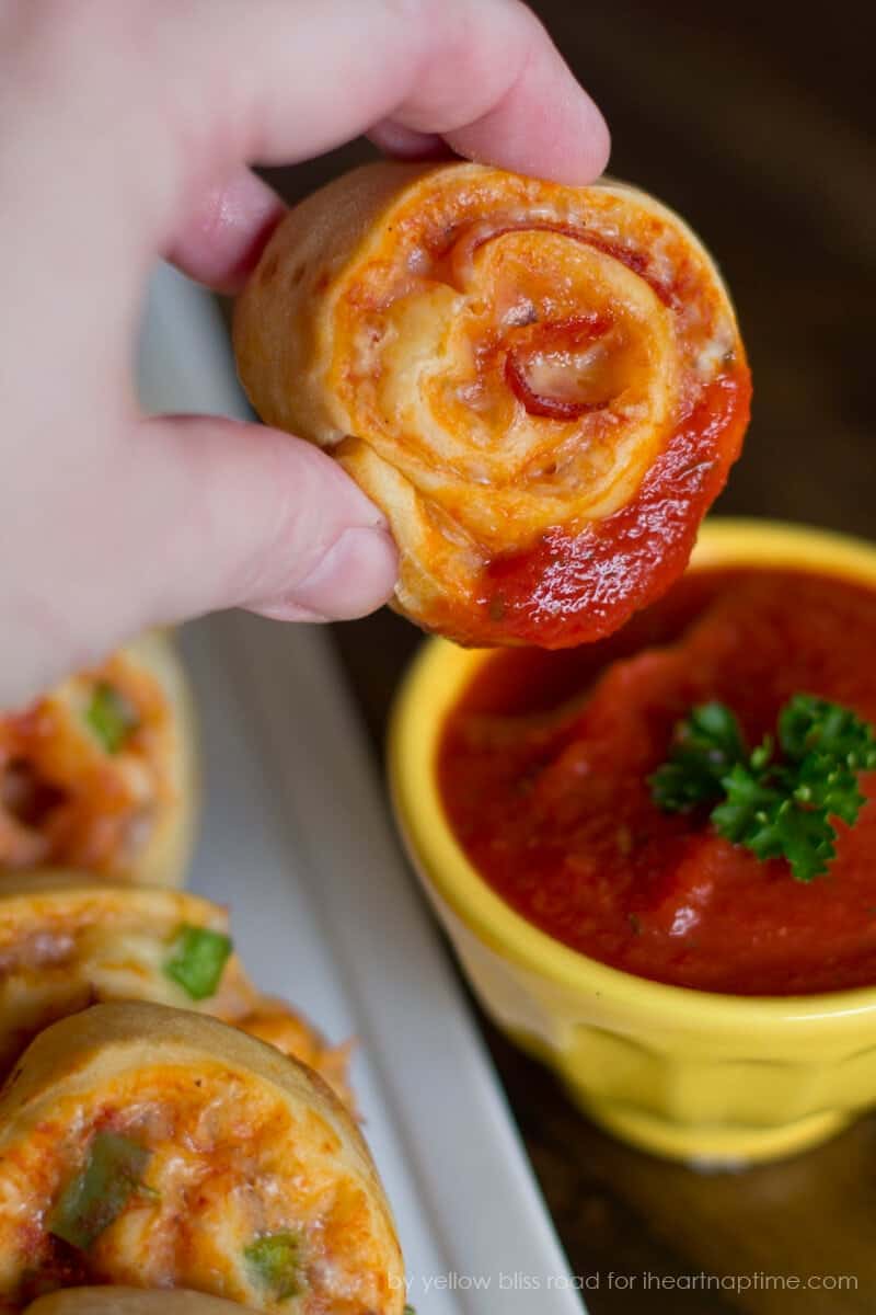 Ein gekochtes Pizzarad in eine Schüssel mit Marinara-Sauce tunken in eine Schüssel mit Marinara-Sauce