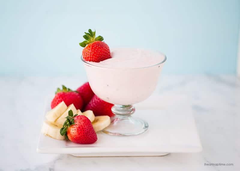 Strawberry fruit dip in a glass bowl served with fresh strawberries and bananas.