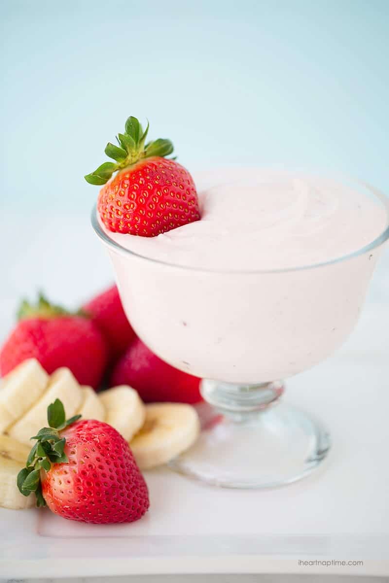 Homemade fruit dip in a glass bowl with fresh strawberries and bananas.