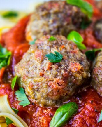 A close up of a pepperoni meatball with marinara