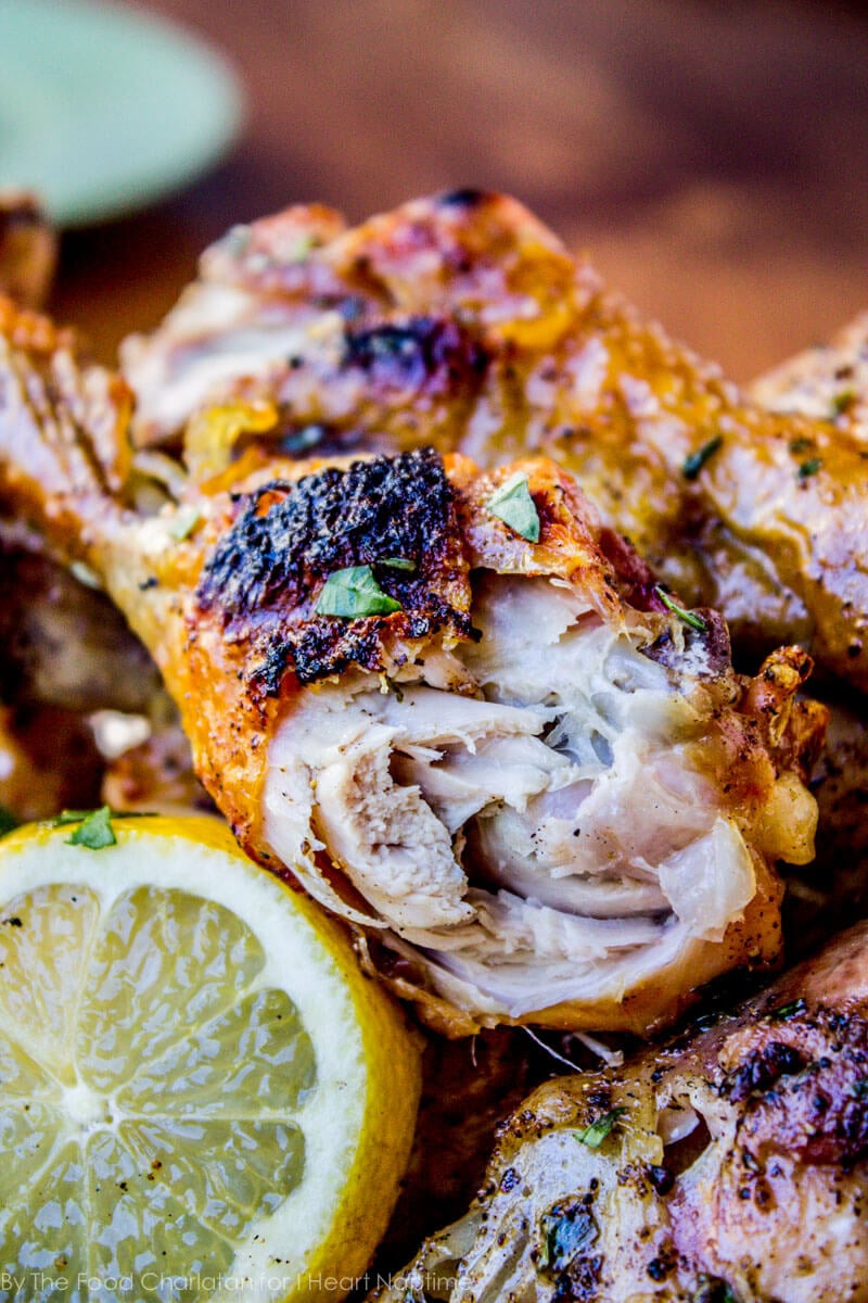A close up of grilled lemon tarragon chicken with a bite taken out 