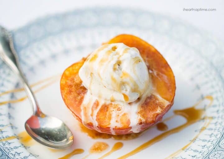 baked peach on a plate with ice cream and caramel sauce on top 