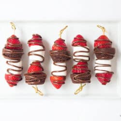 chocolate strawberry dessert kabobs on a white serving plate