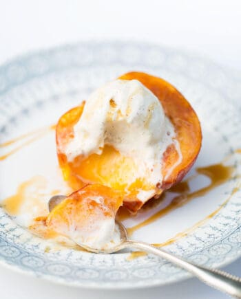 baked peach on a plate with ice cream on top