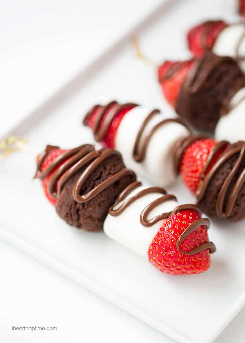 Strawberry dessert kabobs with a chocolate drizzle.