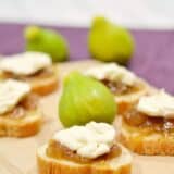 fig and brie bites sitting on wooden board