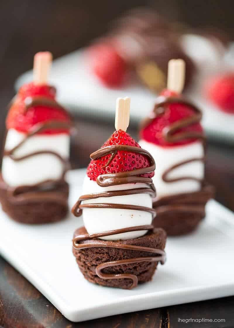 chocolate strawberry kabobs upright on a white plate 