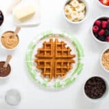 waffle on a paper plate with toppings on the counter