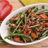 bowl of green beans with red peppers and pecans