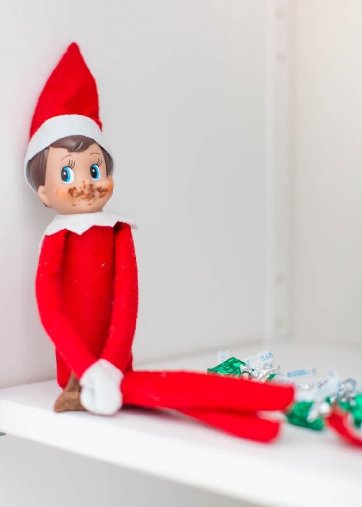 Elf eating chocolate kisses on the shelf.