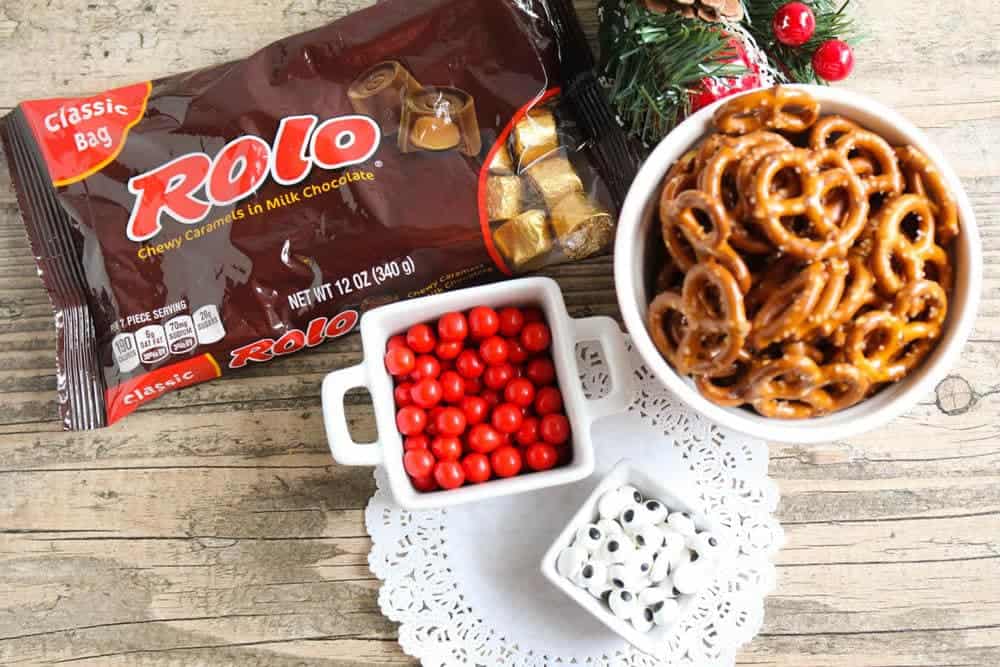 These Rolo Pretzel Reindeer are the perfect treats for the holiday season and so easy to make! Only takes 4 ingredients and a few minutes to bake. rolo pretzel reindeer ingredients on table