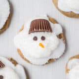 Melted Ginger Snowman Cookies - with a marshmallow belly, Reese's Peanut Butter Cup hat and chocolate chips for the eyes. Such a creative and kid-friendly dessert for the holidays!