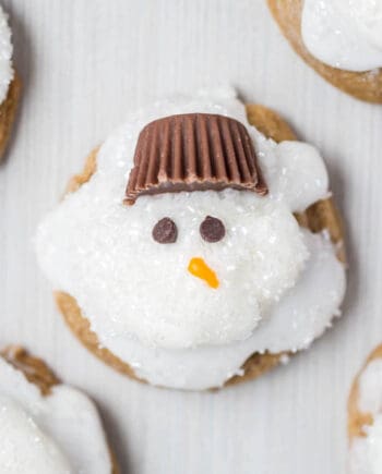 Melted Ginger Snowman Cookies - with a marshmallow belly, Reese's Peanut Butter Cup hat and chocolate chips for the eyes. Such a creative and kid-friendly dessert for the holidays!