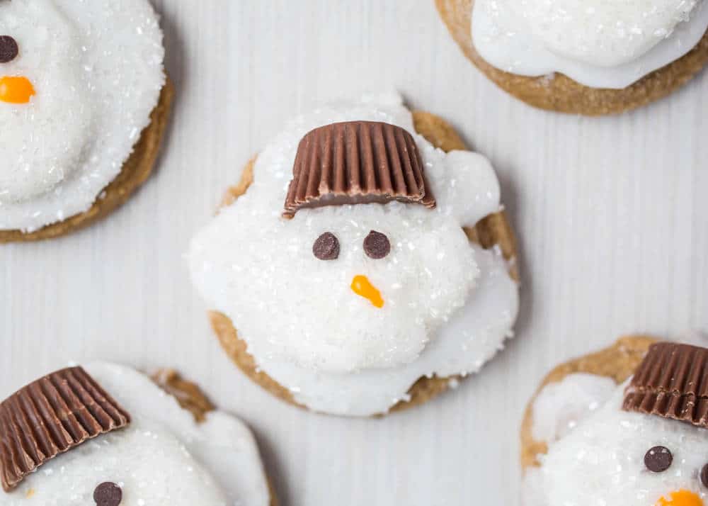 Melted Ginger Snowman Cookies - with a marshmallow belly, Reese's Peanut Butter Cup hat and chocolate chips for the eyes. Such a creative and kid-friendly dessert for the holidays!