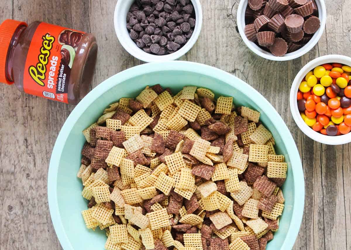 Reeses muddy buddies ingredients on wooden counter.