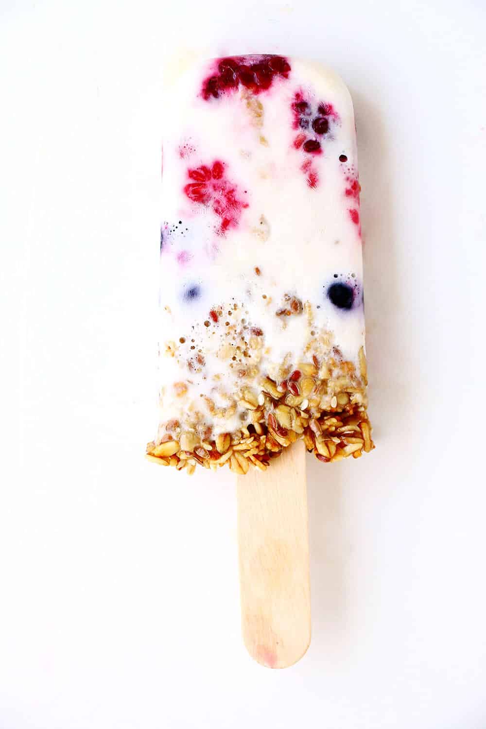 Breakfast popsicle with berry and granola.