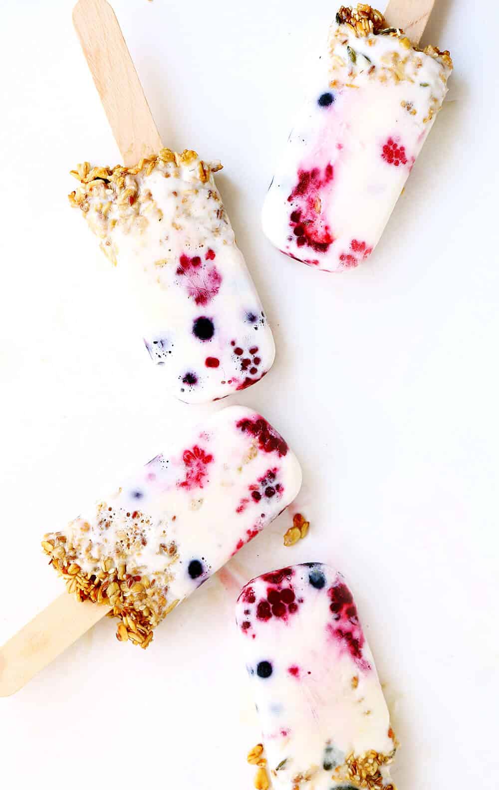 Breakfast popsicles with berries and granola.