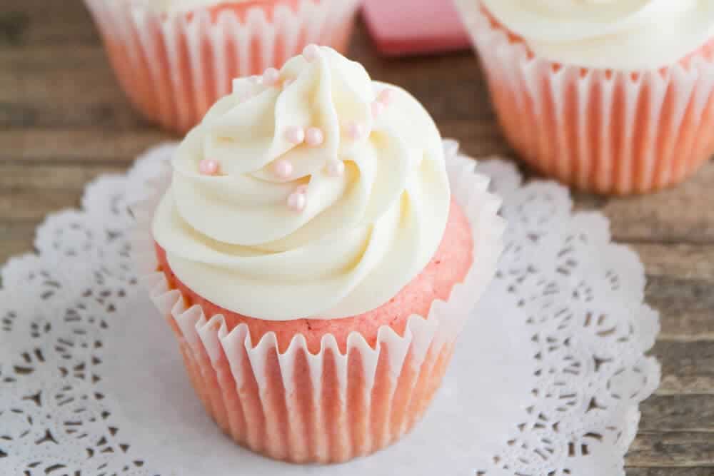 Pink velvet cupcake with cream cheese frosting.