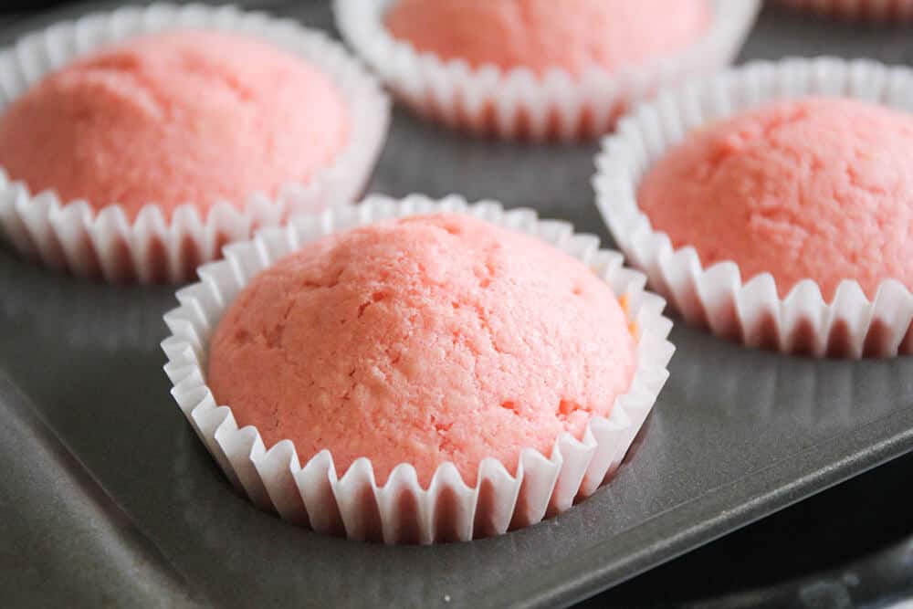 Pink cupcakes in a cupcake pan.