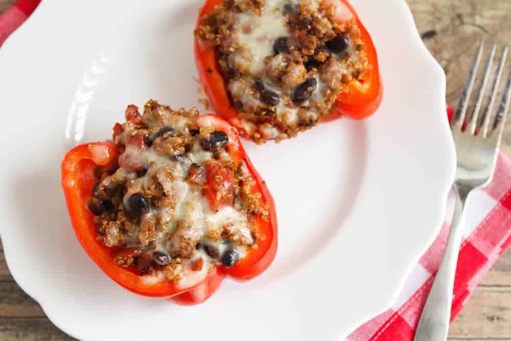 Quinoa stuffed bell peppers on a white plate.