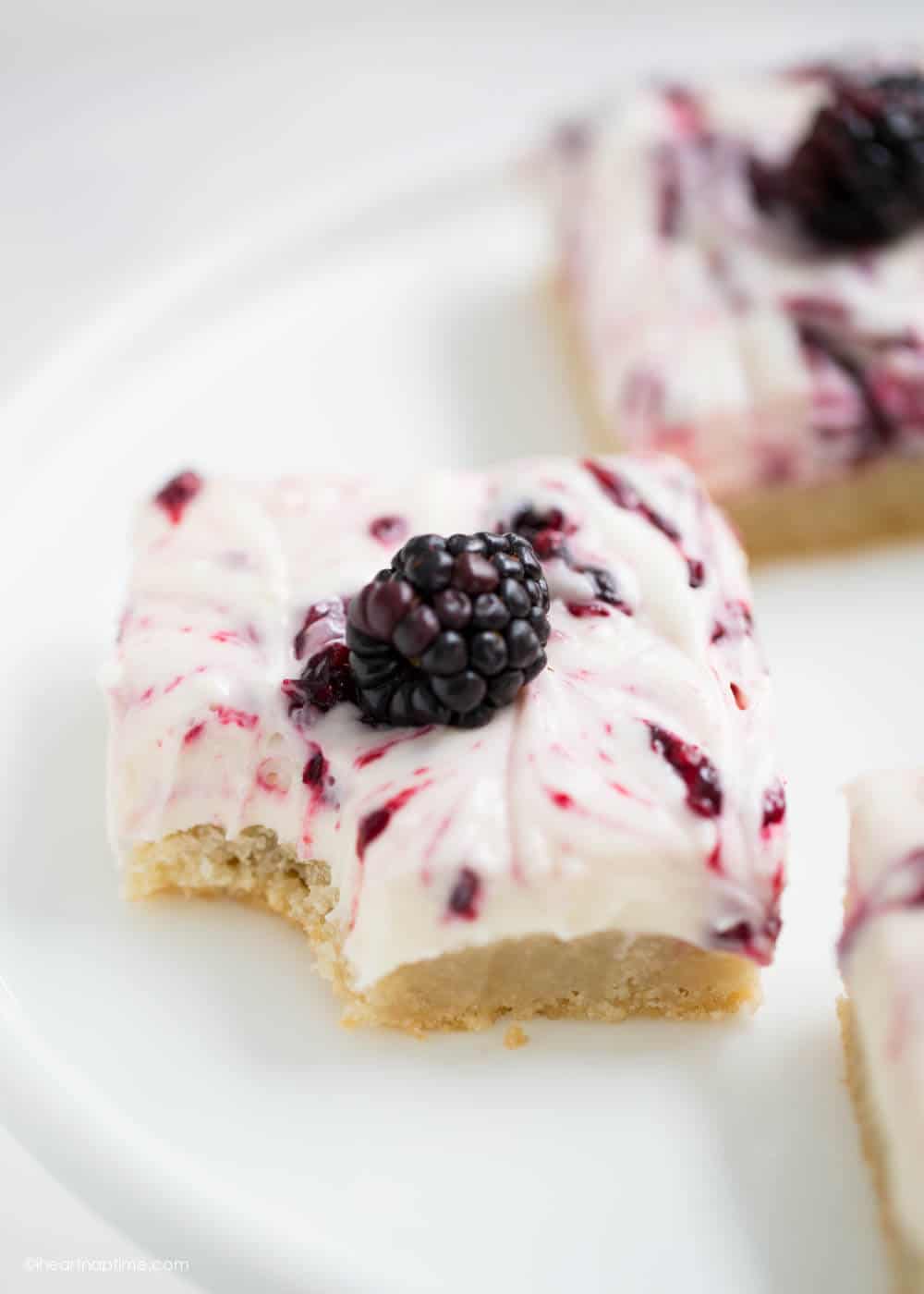 Blackberry cheesecake bar with a bite taken out.