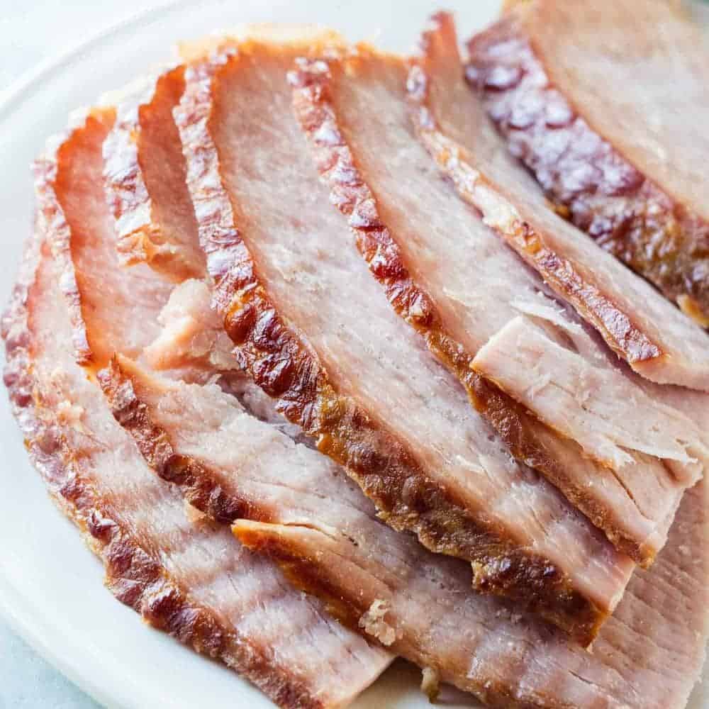 Spiral ham slices on a white plate.