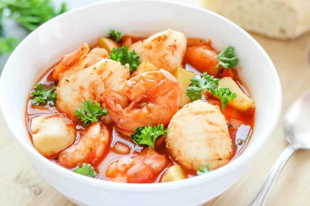Slow Cooker Seafood Stew - a delicious seafood recipe cooked in a tomato-based broth with potatoes. This stew is comforting and is an easy to make dinner recipe!