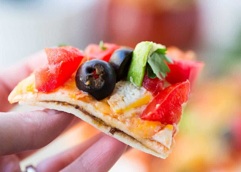 Delicious warm tortillas stuffed with refried beans, meat and melty cheese. Add your favorite toppings and there you have it...a yummy Mexican pizza made in just minutes! slice of mexican pizza